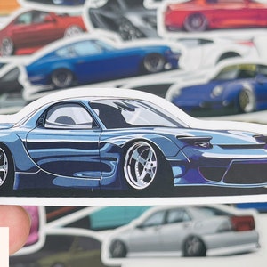 Puede incluir: Una pegatina de coche deportivo azul y plateado sobre fondo blanco. El coche es un coup&eacute; con un perfil bajo y un dise&ntilde;o elegante. La pegatina es perfecta para a&ntilde;adir un toque de estilo a cualquier coche, port&aacute;til o cuaderno.