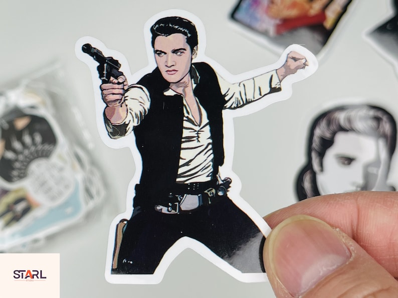 May include: A sticker featuring a black and white illustration of a man with dark hair wearing a black vest and a white shirt. He is holding a gun in his right hand and has a serious expression on his face.