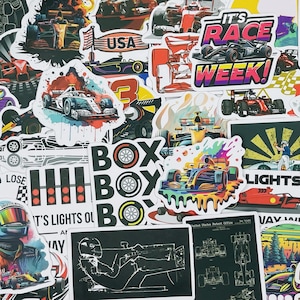 May include: A collection of colorful stickers featuring race cars, checkered flags, and phrases like "It's Race Week!" and "Lights Out".