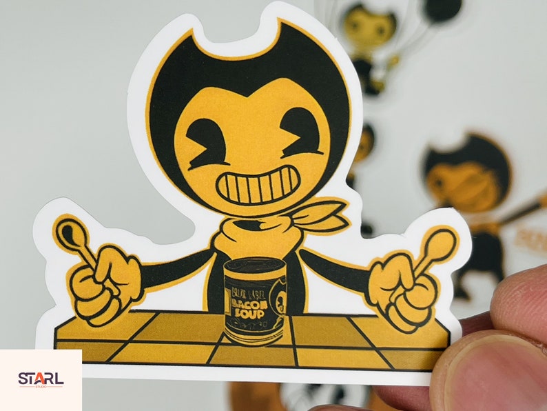 May include: A yellow cartoon character with black eyes and a black bow tie holding a spoon in each hand. The character is sitting at a table with a can of "Blue Label Bacon Soup" in front of them.