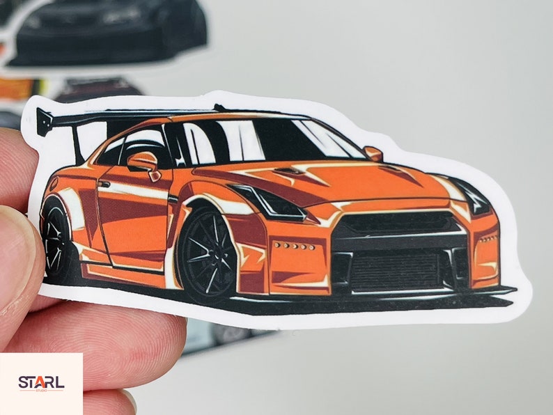 Puede incluir: Pegatina de coche naranja y negro con una ilustraci&oacute;n detallada de un coche deportivo. El coche tiene un gran aler&oacute;n trasero y un kit de carrocer&iacute;a ancho.