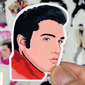 May include: A sticker featuring a cartoon illustration of Elvis Presley with a red turtleneck sweater and a black pompadour hairstyle.