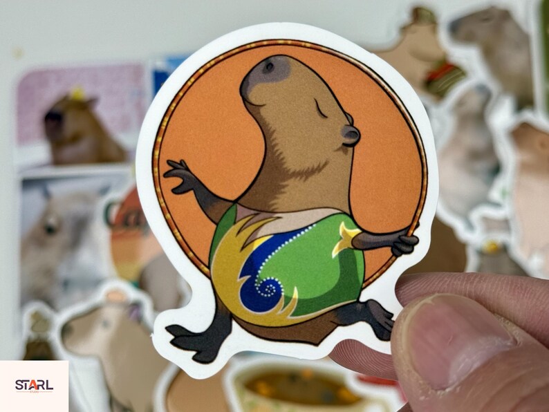 May include: A sticker featuring a cartoon capybara with a brown body, black feet and arms, and a green and yellow patterned shirt. The capybara is set against an orange circle.