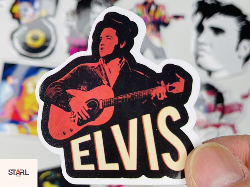 May include: A sticker featuring a black and white illustration of Elvis Presley playing a red electric guitar. The sticker has the word "ELVIS" in large, yellow letters.