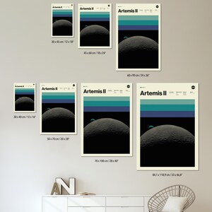 May include: A collection of Artemis II art prints in various sizes, showcasing a minimalist design of a planet with blue and teal stripes. The prints range from 12x16 inches to 33x46.8 inches, with the text "AVAILABLE IN DIFFERENT PRINT SIZES" at the top.