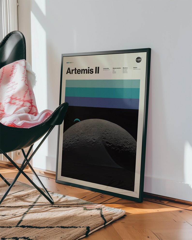 May include: Framed poster featuring the Artemis II mission. The poster has a black frame and displays the mission name, a series of horizontal blue and teal stripes, and a detailed image of the moon's surface. The NASA logo is visible in the top right corner.