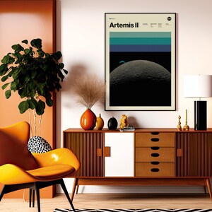 May include: A mid-century modern living room scene featuring an orange chair, a wooden cabinet, and a framed "Artemis II" poster. The room is decorated with a large plant, decorative vases, and a black and white patterned rug. A black and white lamp sits on the cabinet.