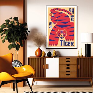 May include: A vintage-style poster featuring a red and blue tiger with the text "20 gram Tiger" and Chinese characters. The poster is framed and hanging on a white wall above a mid-century modern dresser.