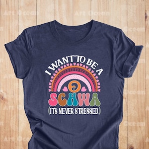 May include: A navy blue t-shirt with a rainbow graphic and the text "I want to be a schwa (it's never stressed)".