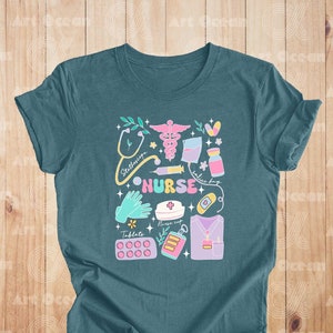 May include: Teal blue t-shirt with a colorful graphic design of medical symbols and the word "NURSE".