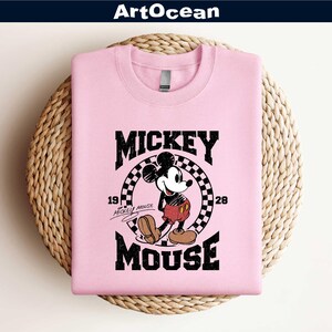 a pink mickey mouse shirt sitting on top of a basket
