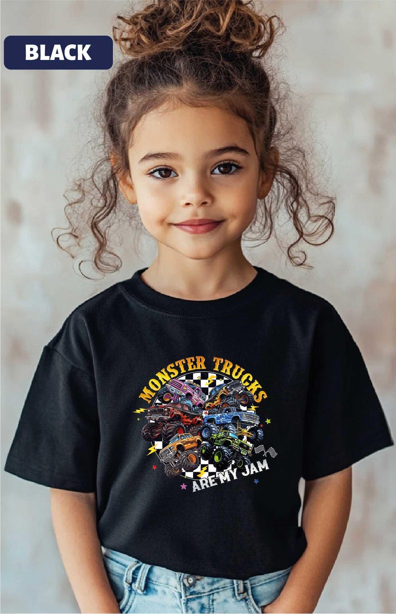 A young girl with curly hair wearing a black t-shirt with a graphic design of monster trucks and the text "Monsters Trucks Are My Jam" printed on it.