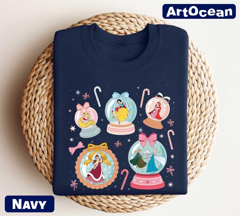 A navy blue t-shirt with a colorful graphic design featuring snowglobes and various Disney princess characters.