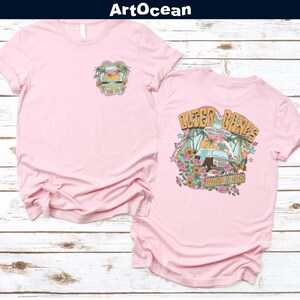 a couple of pink shirts sitting on top of a wooden floor
