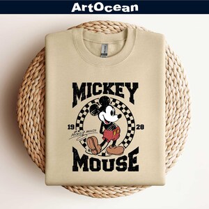 a mickey mouse t - shirt hanging on a wall