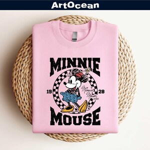 a pink shirt with a mickey mouse graphic on it