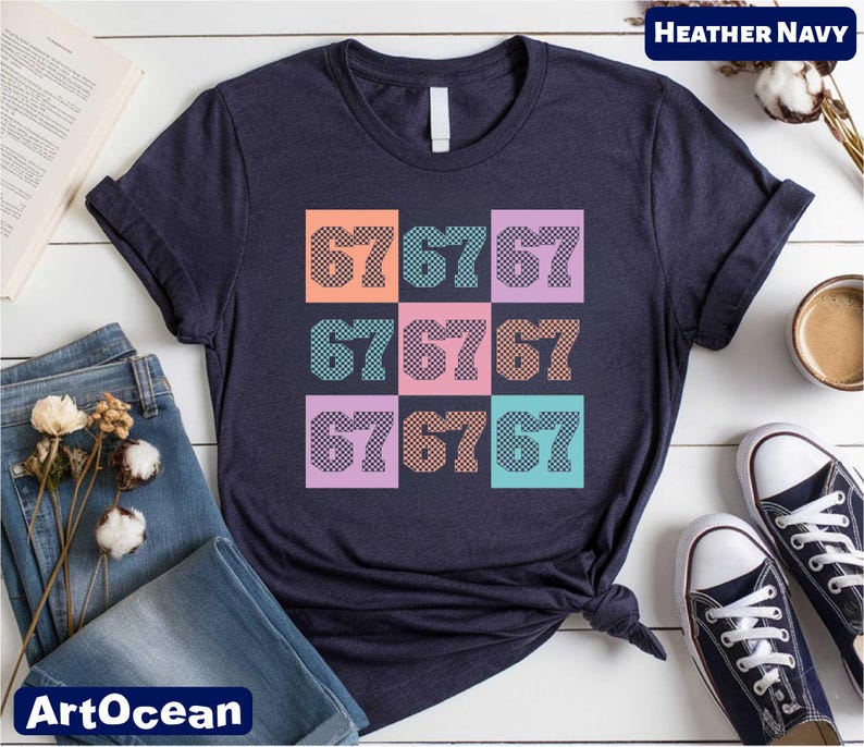 a navy blue t-shirt with a colorful graphic design of numbers on it, along with some casual clothing items such as jeans and sneakers, and a book.