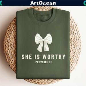 May include: A green t-shirt with a white bow and the text "She is Worthy Proverbs 31" printed on it.