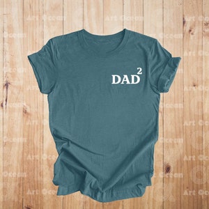May include: A teal blue t-shirt with the text "DAD^2" printed in white on the front.