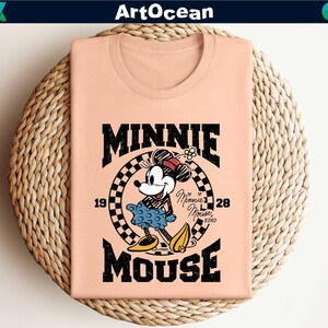 a pink shirt with a mickey mouse graphic on it