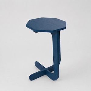 Peut inclure: Une table d'appoint bleue avec un plateau octogonal et un design de pied incurvé unique. La base de la table présente un support en forme de X, et la hauteur totale est d'environ 61 cm.