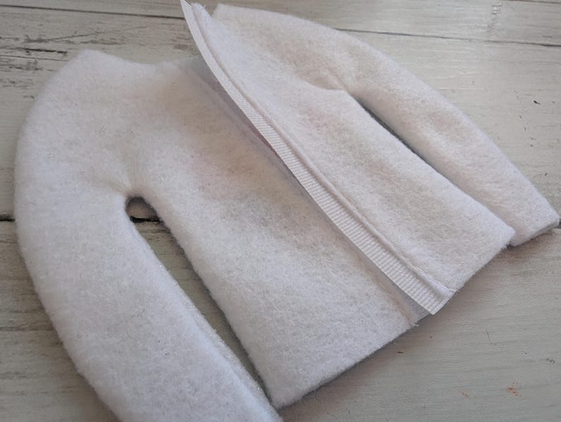 May include: White fleece fabric with a zipper sewn along the center seam. The fabric is folded in half, showing the inside of the fabric.