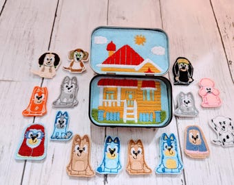 May include: A set of felt finger puppets featuring a yellow house with a red roof and various dog characters. The puppets are colorful and have embroidered details.