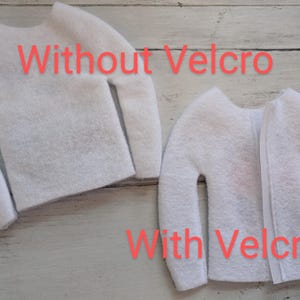 May include: Two white felt sweaters, one with Velcro closure and the other without. The sweater with Velcro has the text "With Velcro" printed below it. The sweater without Velcro has the text "Without Velcro" printed above it.