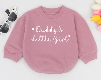 May include: A pink long-sleeved sweatshirt with the text "Daddy's Little Girl" in white.