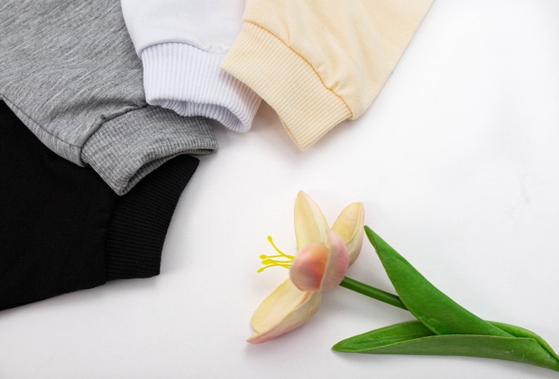 May include: Four different coloured fabric swatches with a pink flower with green leaves on a white background.