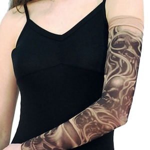 May include: A black and grey skull and flame tattoo sleeve. The sleeve is made of a sheer, stretchy material and is designed to look like a real tattoo.