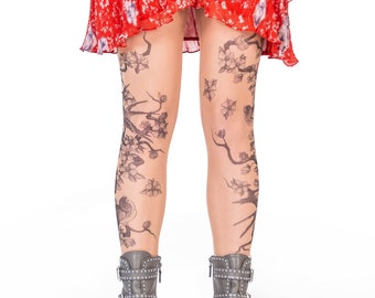 May include: A pair of sheer tights with a black floral pattern. The tights are worn with a red floral skirt and gray ankle boots with buckles and studs.