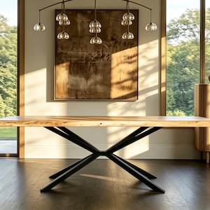 May include: A large, rectangular wooden dining table with a natural finish. The table has a live edge and is supported by a black metal base. The table is approximately 96 inches long and 40 inches wide.