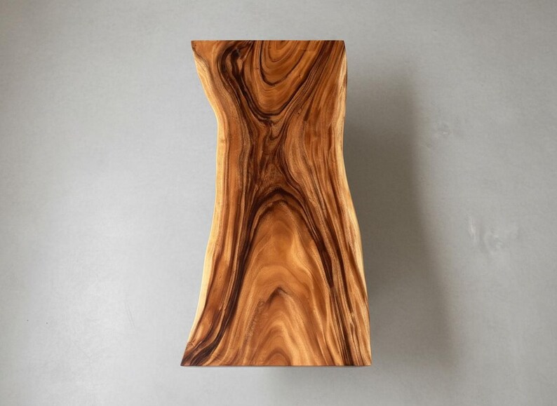Puede incluir: Una losa de madera rectangular con borde vivo, de forma natural y org&aacute;nica. La madera presenta un color marr&oacute;n c&aacute;lido y rico con vetas oscuras y arremolinadas. La losa es probablemente una pieza decorativa o funcional, como un estante o una mesa.