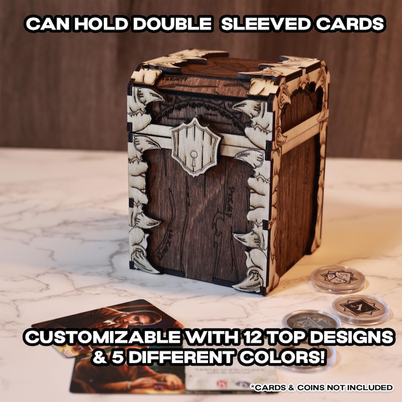 K&ouml;nnte beinhalten: Eine Holzkiste mit einem dekorativen Design, mit einem Riegel und einem Schl&uuml;sselloch. Die Kiste ist mit 12 Oberseiten-Designs und 5 verschiedenen Farben anpassbar. Sie kann Karten mit doppelter H&uuml;lle aufnehmen. "CARDS & COINS NOT INCLUDED" steht am unteren Rand des Bildes.