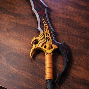 May include: A decorative dagger with a curved blade. The blade is black with red accents and a silver edge. The handle is wrapped in tan leather. The hilt features gold and yellow decorative elements. The dagger is approximately 15 inches long.