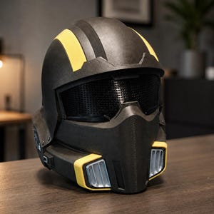 May include: A matte black full-face helmet featuring two prominent yellow stripes running over the top, a dark mesh visor, and a lower face guard with silver-coloured vents framed by yellow accents on both the left and right sides of the chin.