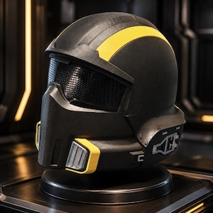 May include: A matte black helmet featuring a prominent yellow stripe running across the top and yellow accents near the chin guard. The helmet includes a dark, textured mesh visor and mechanical-looking side details with silver-toned hardware.
