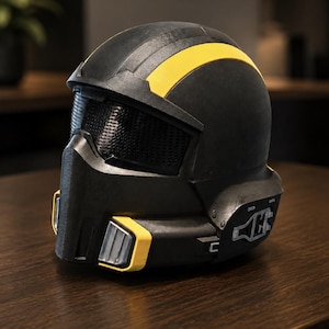 May include: A matte black full-face helmet featuring a prominent yellow stripe running across the top, a dark mesh visor, and yellow-accented vents on the lower front section. The side of the helmet displays a silver mechanical detail.