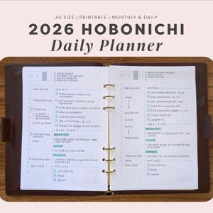Può includere: Un'agenda giornaliera Hobonichi 2026 in una copertina in pelle marrone scuro con anelli dorati. Le pagine aperte presentano un layout a griglia con programmi giornalieri, liste di cose da fare e piani alimentari scritti a mano in inchiostro blu. Testo: 2026 HOBONICHI Daily Planner.