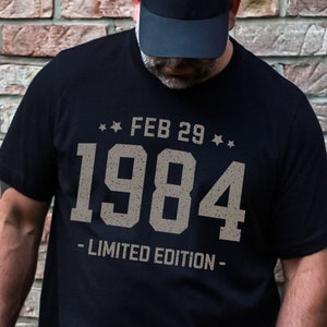 May include: Black t-shirt with a vintage-style graphic that says "FEB 29 1984 - LIMITED EDITION -" in white lettering.