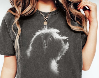 May include: A charcoal gray short-sleeve t-shirt featuring a white graphic print of a dog silhouette in profile. The shirt has a crew neckline and a relaxed fit. The dog graphic is rendered in a soft, textured style, highlighting the fur details.