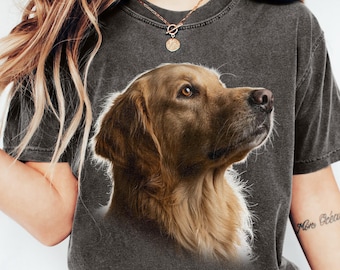 May include: A charcoal grey short-sleeve t-shirt featuring a realistic graphic print of a golden-brown dog's head in profile. The shirt has a crew neckline and a faded, vintage-style wash, paired with blue denim jeans and white sneakers.