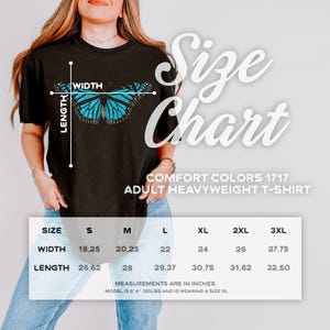 May include: A black t-shirt featuring a blue butterfly graphic and a size chart with measurements in inches. The text reads Size Chart, Comfort Colors 1717 Adult Heavyweight T-Shirt, and lists width and length dimensions for sizes S through 3XL.