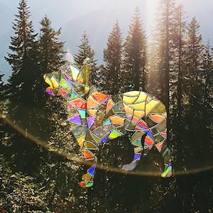 Può includere: Un'immagine colorata in stile vetrata di un cane in piedi in un bosco. Il cane è composto da molti pezzi di vetro di diversi colori, e lo sfondo è un'immagine sfocata di alberi.