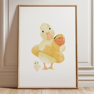 May include: Watercolor print of a duck family. A large yellow duck with a life preserver embraces a smaller duck. A baby duck stands nearby. The artwork is framed in a light brown wooden frame.