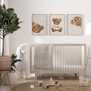 May include: A nursery scene featuring three framed prints of brown teddy bears. The prints are set against a beige and white checkered and striped backdrop. A wooden cot, a white llama, and a woven rug are also visible.