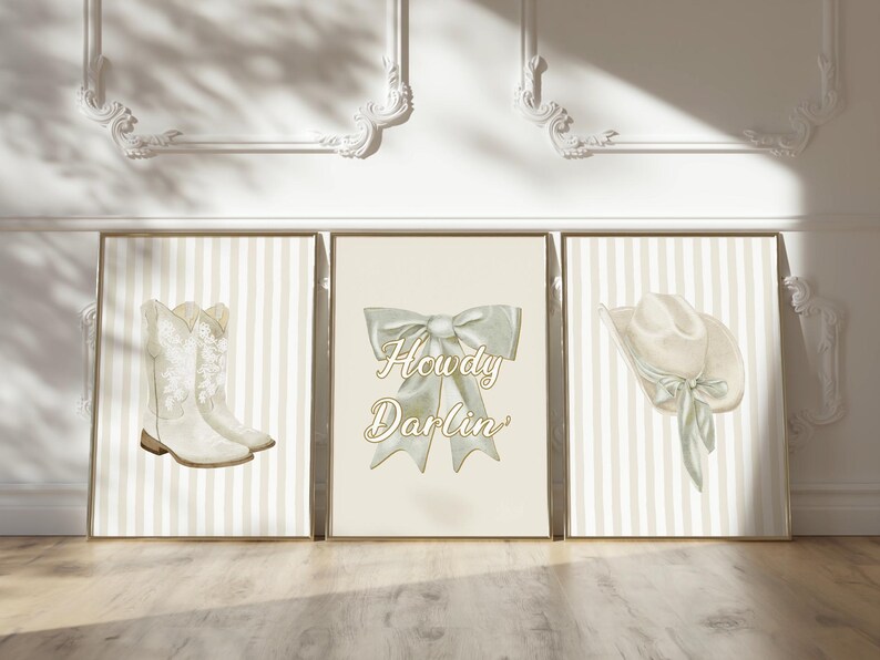 May include: Three framed prints with a country theme. The left print shows white cowboy boots, the center print has a bow with the text "Howdy Darlin'", and the right print features a cowboy hat. All prints have a striped background.