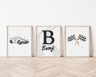 Puede incluir: Tres láminas enmarcadas con temática de carreras. La primera muestra un coche de carreras blanco con el número 1. La segunda presenta una gran letra "B" con el nombre "Benji" y huellas de neumáticos. La tercera muestra banderas a cuadros cruzadas.
