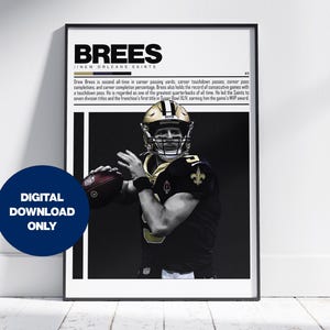 May include: A black and white poster with a photo of Drew Brees, a professional football player, wearing a New Orleans Saints uniform and helmet. The poster has the text "BREES" in bold, white letters and the text "NEW ORLEANS SAINTS" in smaller, white letters. The poster also includes a short biography of Drew Brees.
